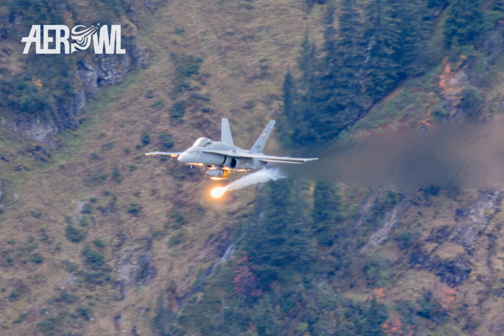 A Swiss Air Force Boeing F/A-18C Hornet deploys flares during the start of the Axalp Fliegerschiessen 2018 in the Swiss Alps.