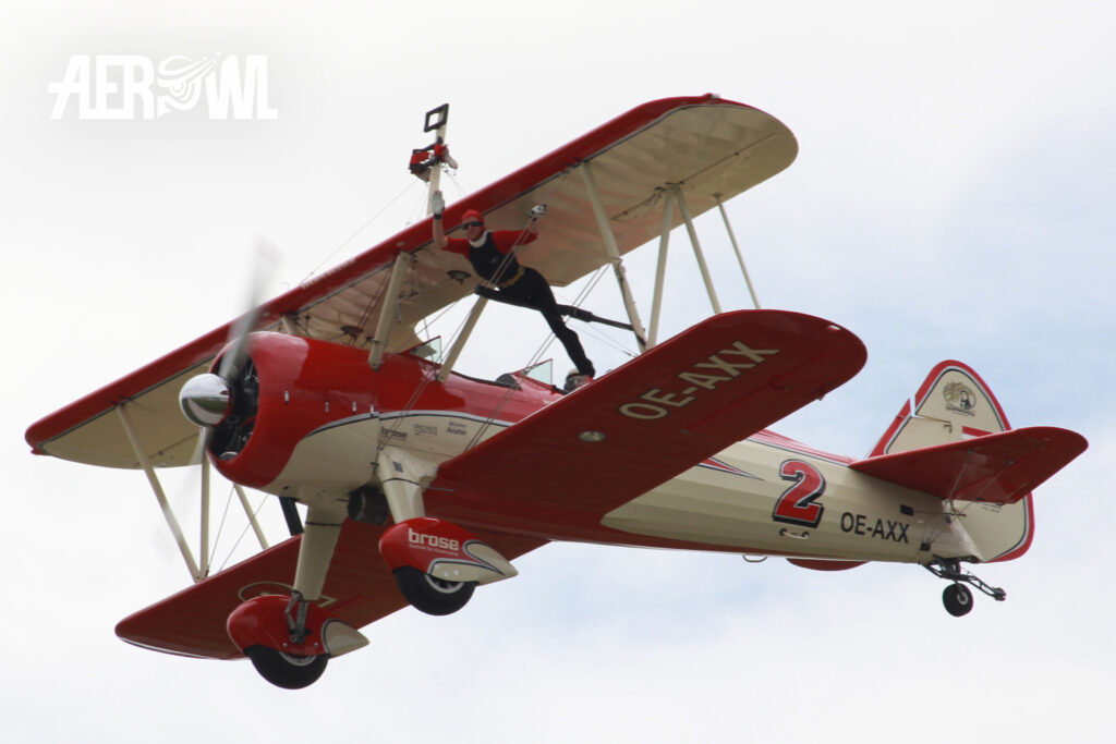 Wingwalker Peggy Krainz on a Boeing A75N1 Stearman (PT-17-BW) during the ILA 2014 over the BER airport Berlin-Brandenburg in Germany.